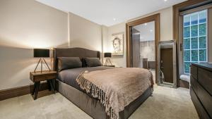 a bedroom with a large bed and a television at Luxury Interior Designed 3 Bedroom Apartment in Central London in London