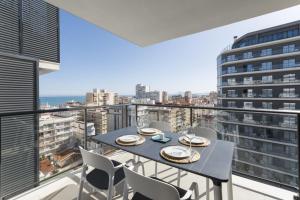 a table and chairs on a balcony with a view of the city at AG El Alamo in Playa de Gandia