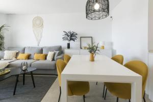 a living room with a white table and yellow chairs at AG El Alamo in Playa de Gandia