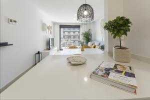 a living room with a book on a white floor at AG El Alamo in Playa de Gandia +81 photos