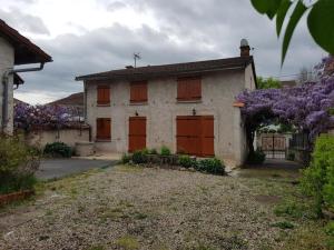 an old house with red doors and purple flowers at Grande maison idéale réunions familiales in Nervieux