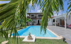 a villa with a swimming pool and a palm tree at Alpinia villa O'Mangos in Saint-François