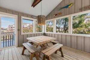 a dining room with a table and benches and windows at Hostetler in Duck