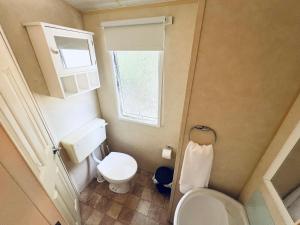 a small bathroom with a toilet and a window at 2 Bedroom Caravan GW39, Thorness Bay, Isle of Wight, Dog Friendly in Porchfield +8 photos