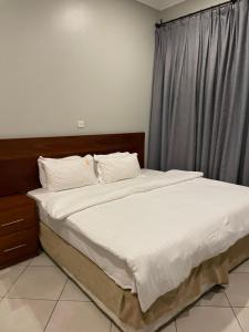a bed with white sheets and pillows in a bedroom at Attorney Pad in Arusha