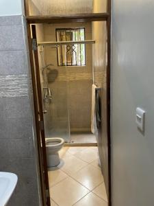 a bathroom with a toilet and a glass shower at Attorney Pad in Arusha +8 photos