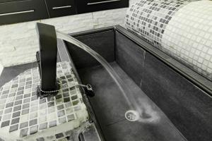 a bathroom with a sink with a faucet at Wellness Studio Tiel met sauna en jacuzzi in Tiel