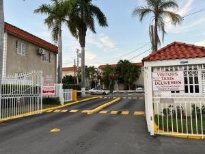 a sign on the side of a street with a fence at Stylish 2BR Prime Location Gated 24 7 Secure in Kingston