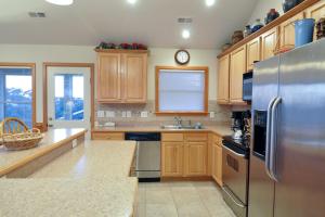 a kitchen with wooden cabinets and a stainless steel refrigerator at Danube Breezes in Nags Head