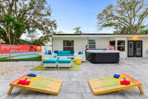 a patio with tables and chairs and a firepit at Resort Style Backyard Pool Sport Court Putt Putt in Seminole