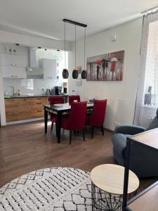 a living room with a table and red chairs at Studija tipa dzīvoklis blakus jūrai in Liepāja