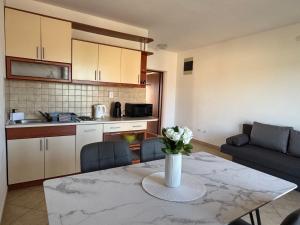 a living room with a table with a vase of flowers on it at Apartments Bernarda 1 in Nin +44 photos