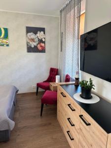 a living room with a table and a red chair at Studija tipa dzīvoklis blakus jūrai in Liepāja
