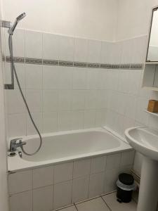 a bathroom with a bath tub and a sink at Appartement cocon in La Teste-de-Buch +4 photos