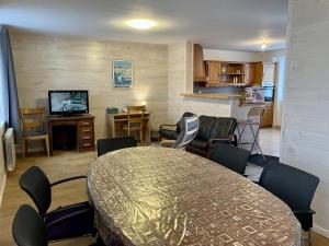 ImphyにあるC3 Familiale Parking 2 chambres 4 lits 5 personnes WiFiのテーブルと椅子、キッチンのあるリビングルーム