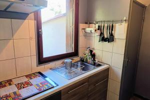 Una encimera de cocina con un fregadero y una ventana. en Pleasant house with garden near beaches, en Bandol