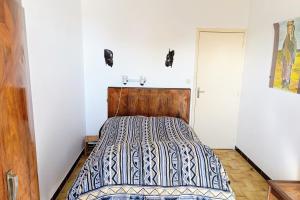 Un dormitorio con una cama con cabecero de madera. en Pleasant house with garden near beaches, en Bandol 7 fotos más