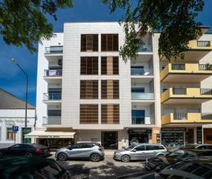 a building with cars parked in front of it at BeGuest City Center in Olhão in Olhão
