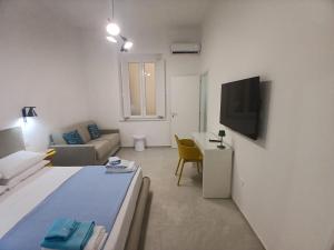 a living room with a bed and a couch and a tv at HOME 23 apartament in Crotone