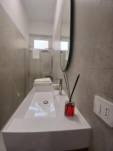 a bathroom with a white sink and a mirror at HOME 23 apartament in Crotone +16 photos