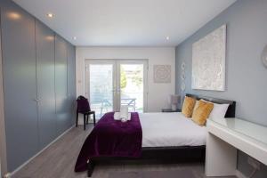 a bedroom with a bed with a purple blanket at Southside Flat with Private Garden! in Glasgow +10 photos