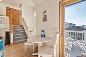 a dining room with a table and a balcony at How Sweet The Sound in Duck