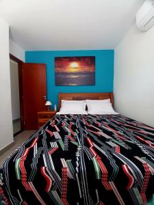 a bedroom with a bed with a colorful blanket at Casa Climatizada com Piscina em Jacaraipe in Serra