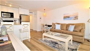 una sala de estar con un sofá y una mesa en Driftwood Dream Unit 12, en Cape May