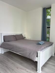 a white bed in a white bedroom with a window at Alhambra House, Modern 2 Bed Flat - F2 in Croydon