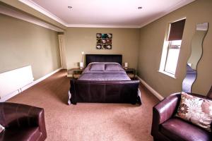 a bedroom with a bed and a couch and a chair at shoreside inn in Shanklin