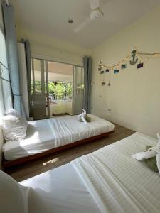 Un dormitorio con dos camas y una gran ventana. en Zen Beach Oasis - Balinese Beachfront House with Stunning Sea View, en Ko Pha Ngan