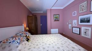 a bedroom with pink walls and a bed with a stuffed animal on it at Appartement cozy style Friends in Nîmes +3 photos
