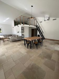 Großes Zimmer mit einem Tisch, Stühlen und einer Treppe in der Unterkunft Villa les Tamaris in Gignac