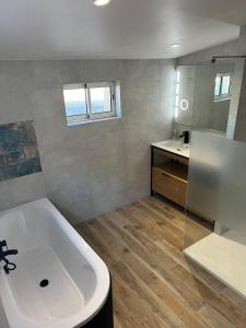 ein Badezimmer mit einer weißen Badewanne und einem Waschbecken in der Unterkunft Villa les Tamaris in Gignac