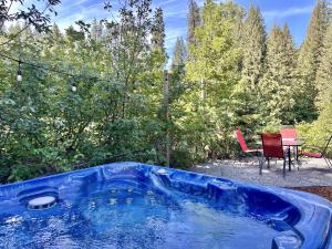 una vasca blu in un cortile con un tavolo e delle sedie di Rivers Edge by NW Comfy Cabins a Leavenworth