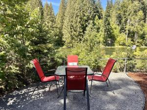 un tavolo e quattro sedie con vista sul lago di Rivers Edge by NW Comfy Cabins a Leavenworth