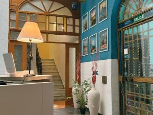 a lobby with a desk and a vase on a wall at Rio Hostel in Seville