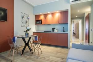 ラ・スペツィアにあるNOEMI chic rooms and apartmentsのテーブルと椅子のあるキッチンとダイニングルーム