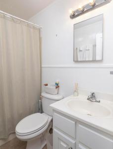 a white bathroom with a toilet and a sink at Grayson Cottage in Oxford