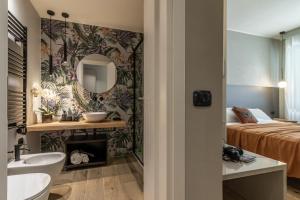 ラ・スペツィアにあるNOEMI chic rooms and apartmentsのベッドと洗面台と鏡のあるバスルーム +65枚の写真