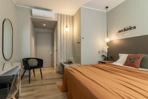 ラ・スペツィアにあるNOEMI chic rooms and apartmentsのベッドと机と椅子のある寝室