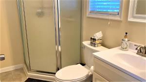 a bathroom with a shower and a toilet and a sink at 208 Pontaxit Avenue, North Cape May in North Cape May +31 photos