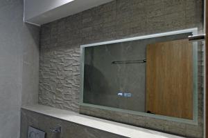 a large mirror on a brick wall in a bathroom at Agios Nikolaos Villas in Agios Nikolaos +289 photos