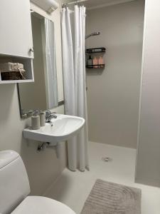 a white bathroom with a sink and a shower at Apartment in Tromsø in Tromsø