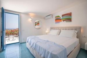 Un dormitorio con una cama grande y un balcón. en Borgo del Cannitello Romantic Boutique Resort, en Vulcano