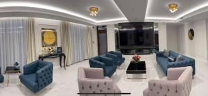 a large living room with blue couches and a piano at Ancora in Salonta