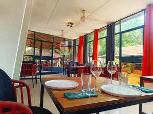 a table with two wine glasses on top of it at Hôtel Les Palmiers in Ouagadougou