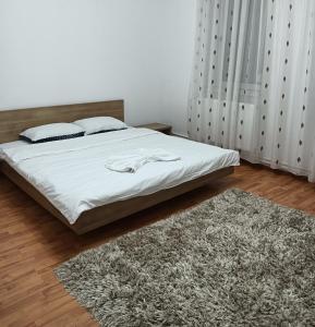 ドロベタ・トゥルヌ・セヴェリンにあるAlex Houseのベッドルーム1室(白いシーツとラグ付)