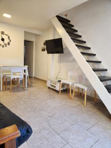 ein Wohnzimmer mit einer Treppe und einem Tisch und Stühlen in der Unterkunft Casa frente al museo MAR in Mar del Plata
