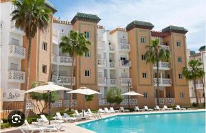a hotel with a swimming pool in front of a building at Casa Amy in Mohammedia